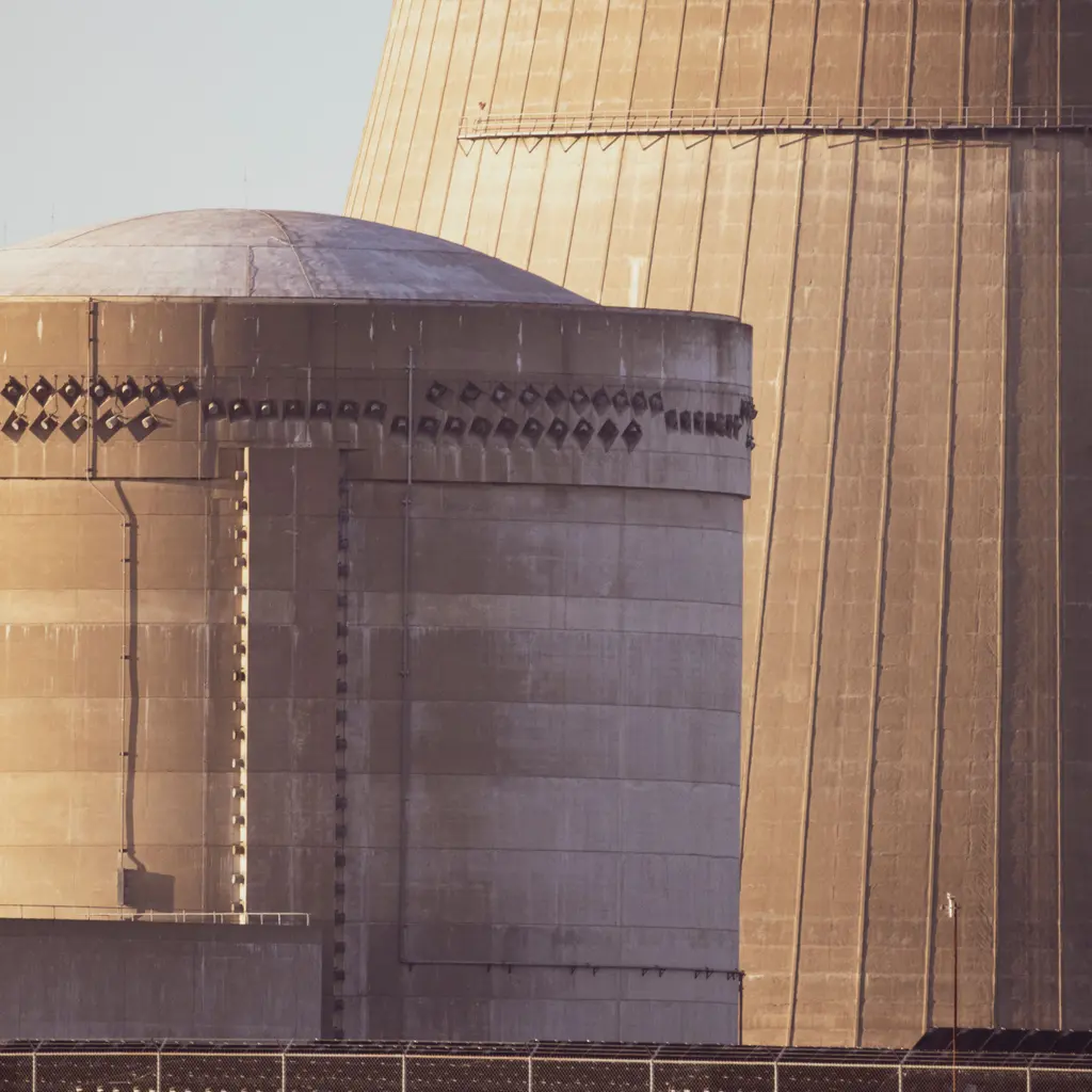 Reactor containment structures beside a cooling tower at a nuclear power station.