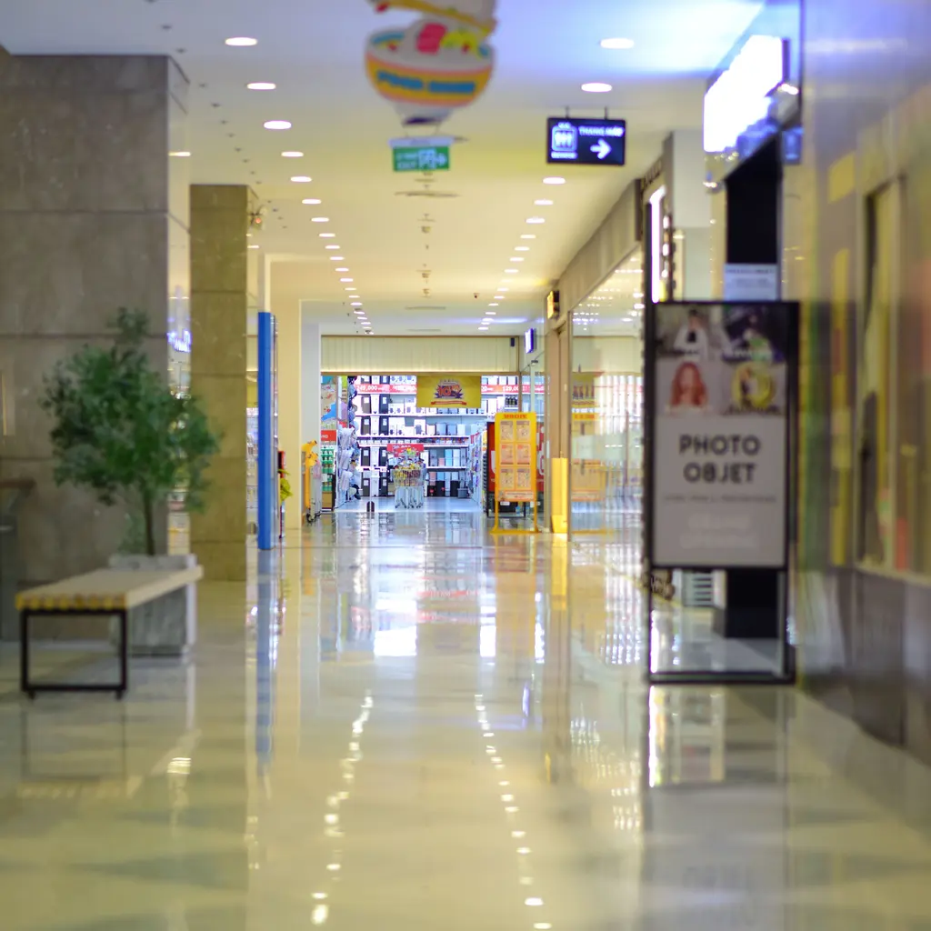 A bright shopping-center corridor lined with retail entrances.