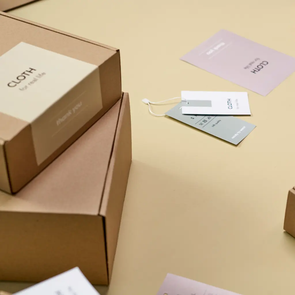 Printed paper labels and tags arranged with kraft cardboard boxes.