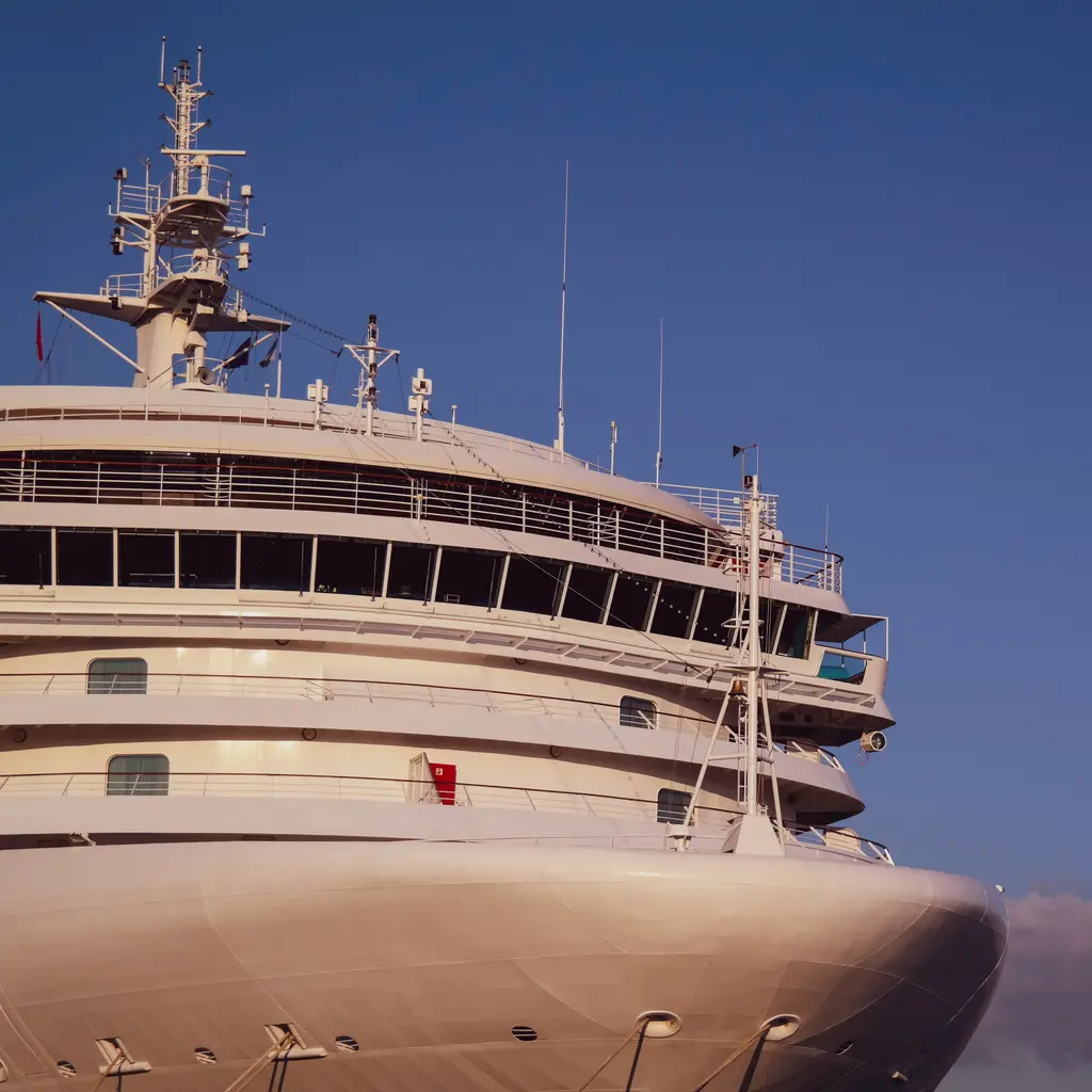 The bow and upper passenger decks of a large cruise ship.