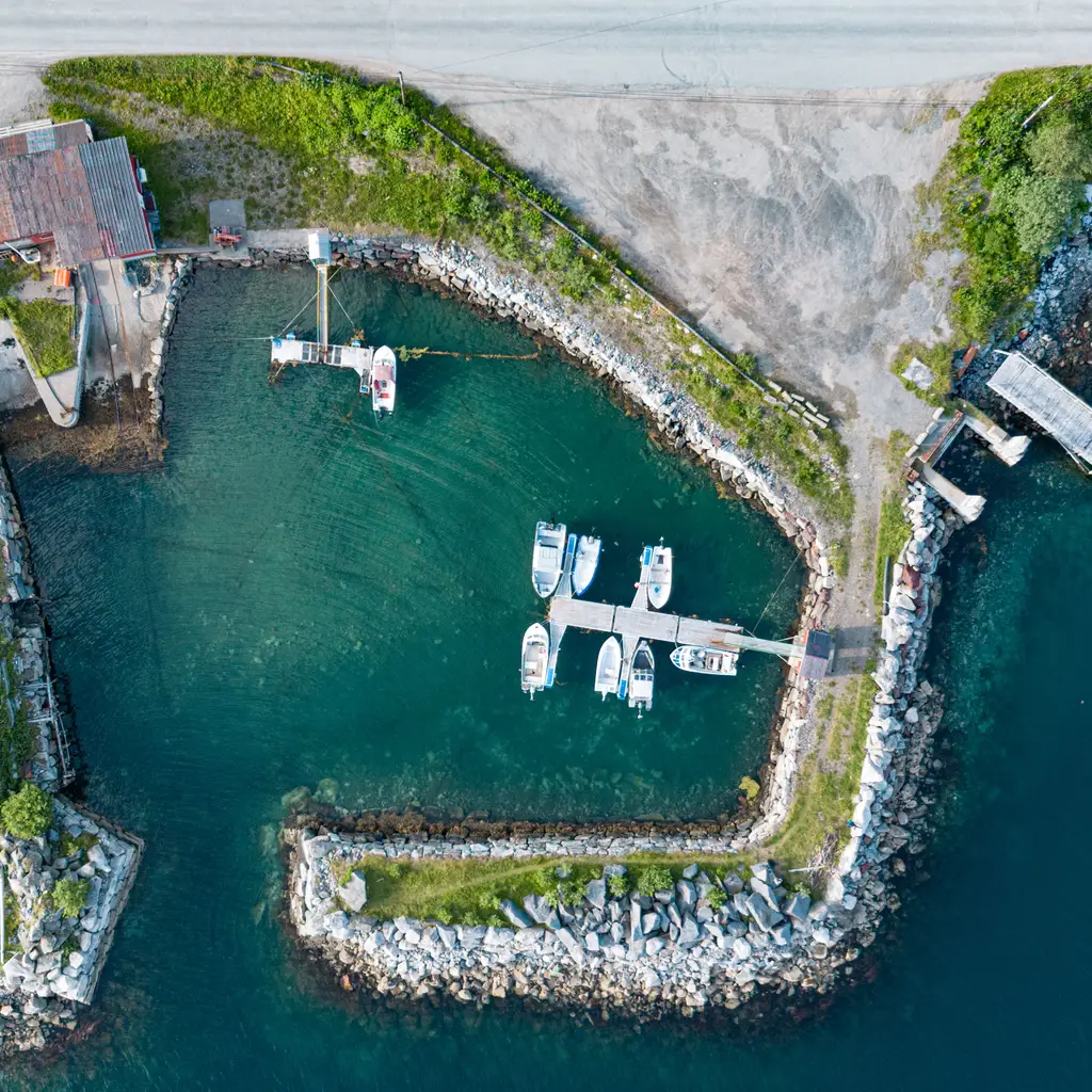 An aerial view of sheltered harbor berths, piers and breakwaters.