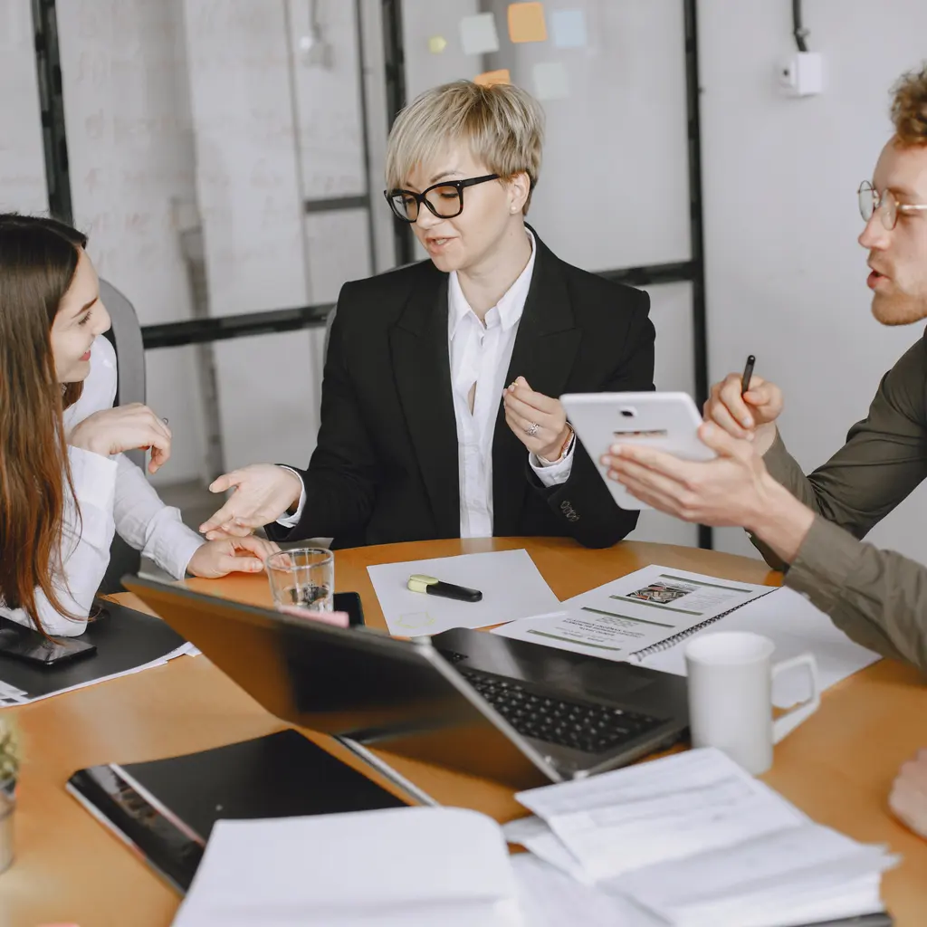 People reviewing printed project documents during a meeting.
