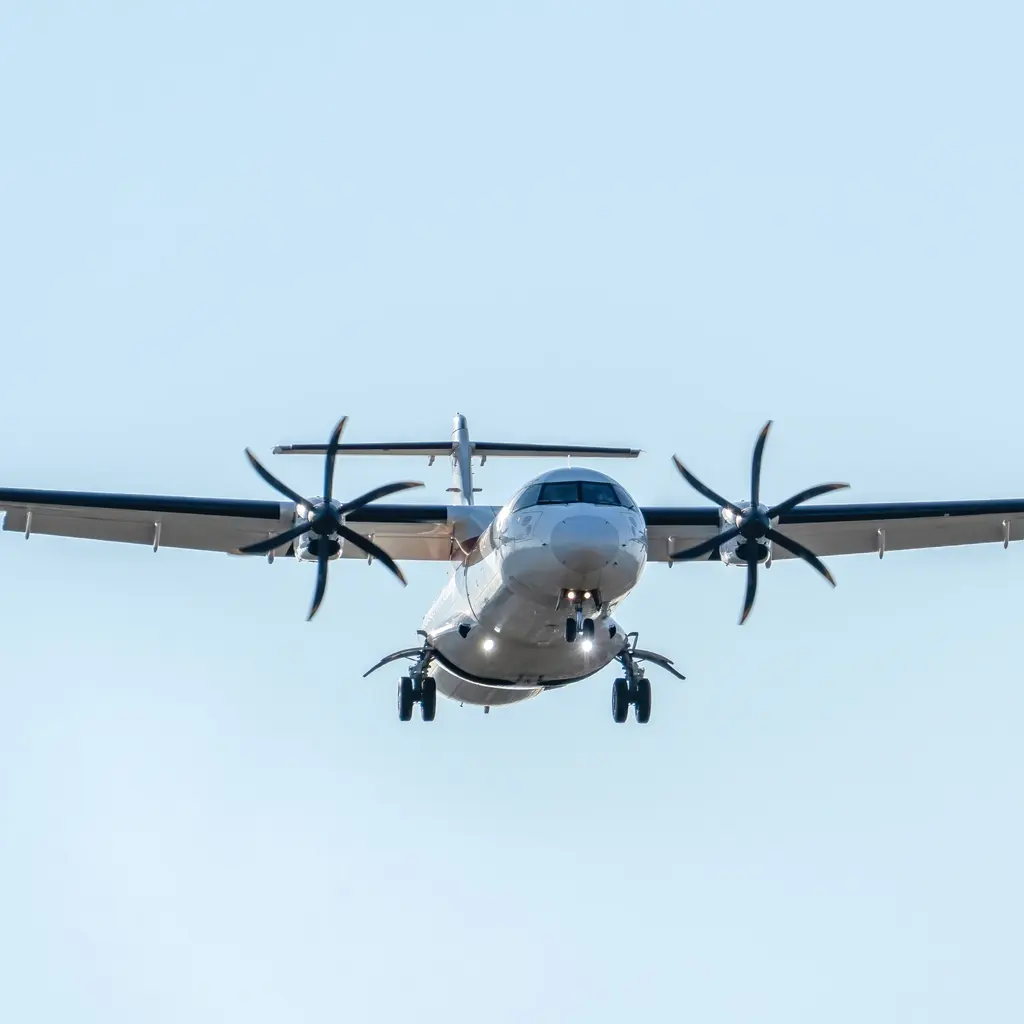 A twin-turboprop regional airliner approaching with landing gear down.