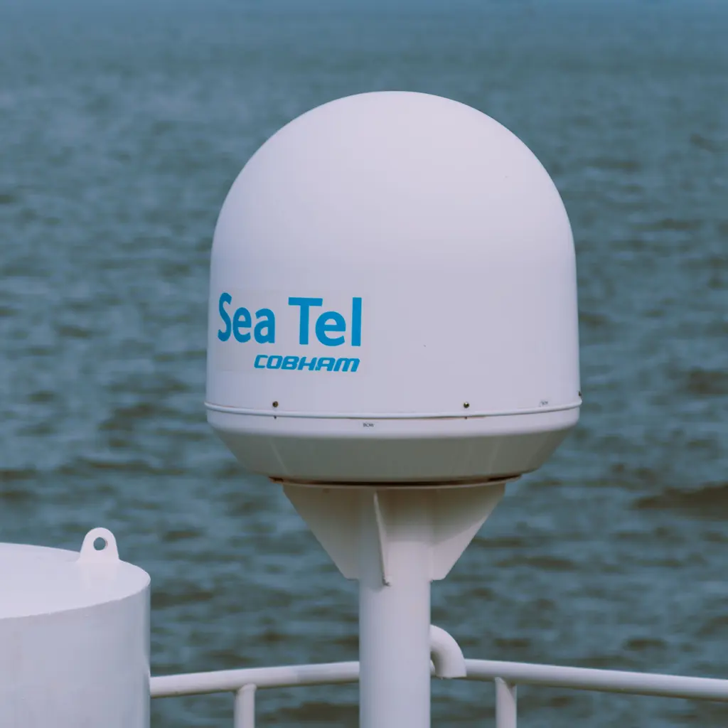 A vessel-mounted satellite antenna inside a white protective radome.