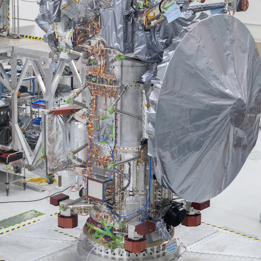 A foil-wrapped spacecraft body and antenna during clean-room assembly.