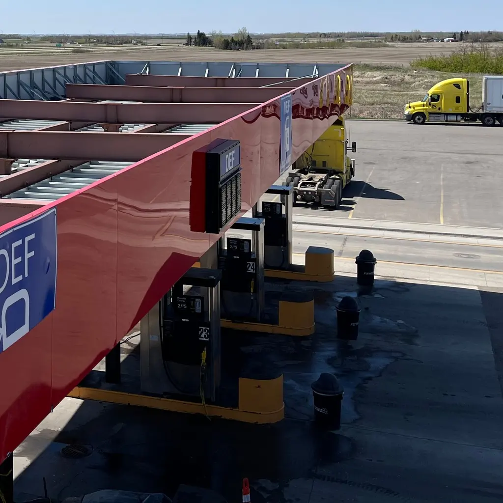 Diesel pump islands and truck access lanes beneath a service-center canopy.
