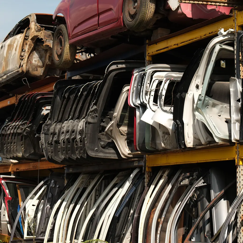 Reclaimed vehicle doors and body panels stored on metal racks.