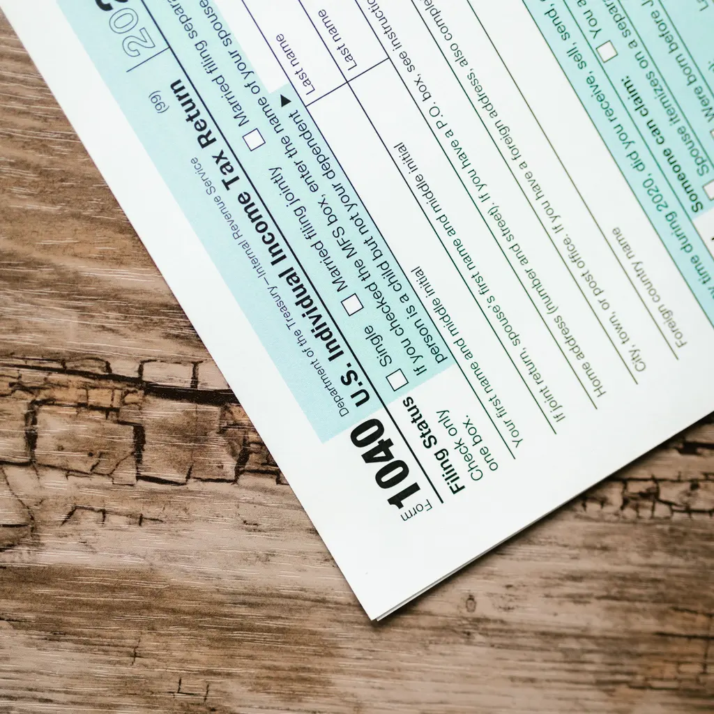 A blank U.S. individual income-tax return form on a wooden desk.