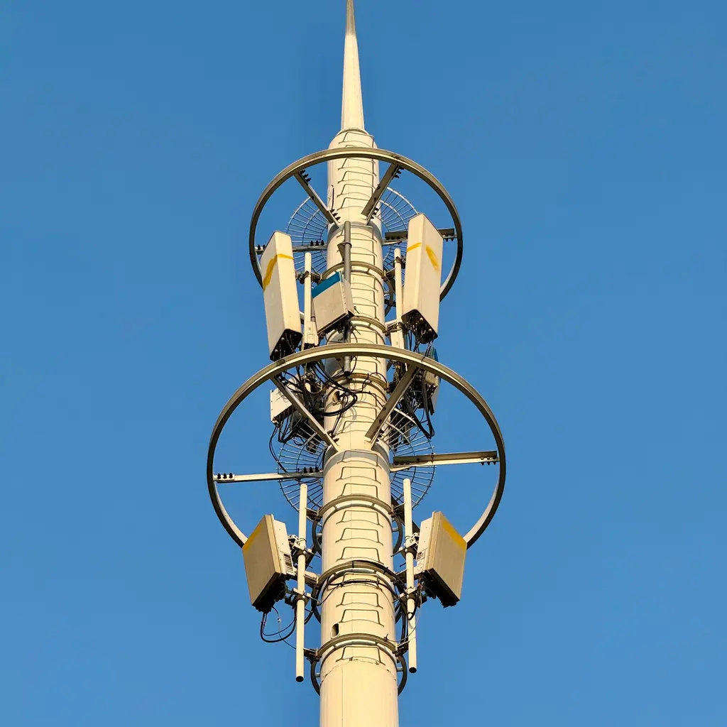Panel antennas, radio enclosures and cables mounted on a cellular-network mast.