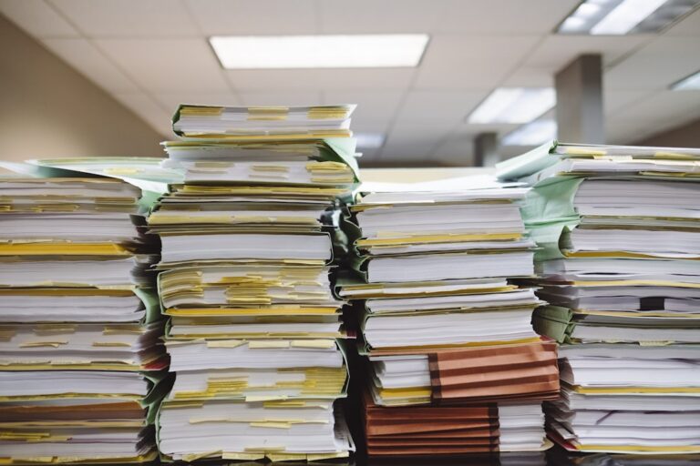 Stacks of paperwork representing the complexities of maximizing benefits this open enrollment season.