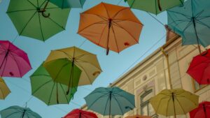 Colorful umbrellas hanging overhead symbolize protection in "Why Life Insurance Matters for Parents This School Year."