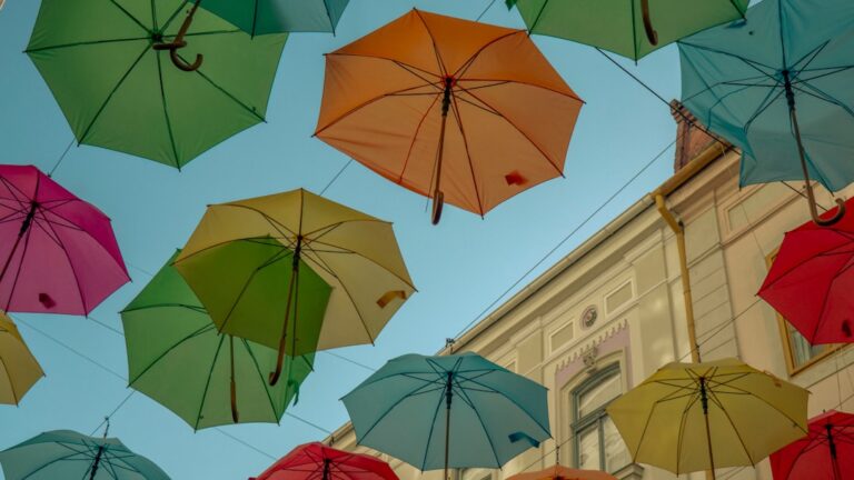 Colorful umbrellas hanging overhead symbolize protection in "Why Life Insurance Matters for Parents This School Year."