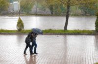"Couple walking under an umbrella in rain, highlighting Back-to-School Health Insurance Tips for College Students."