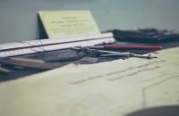 Tools and documents on a desk, symbolizing Group Benefits Compliance: Avoid Costly Legal Mistakes.