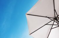 "White umbrella against a blue sky representing how life insurance can strengthen your retirement plan."