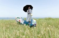 A person stands on a colorful structure in a field, pondering, "Is Your Health Insurance Disaster-Ready? Find Out Now."