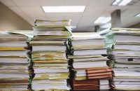 Stacks of paperwork representing the complexities of maximizing benefits this open enrollment season.