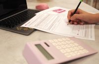 Person reviewing life insurance options with a calculator, emphasizing the need to update your life insurance as your needs evolve.