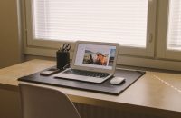 A college desk with a laptop, phone, and stationery, illustrating why students need renters insurance this semester.