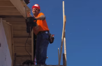 Professional contractor in safety gear, inside a warehouse, emphasizing Workers' Compensation for Contractors compliance